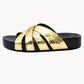 Black slide sandal with gold metallic strap on a white background
