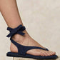 Navy blue sandal worn on a foot against a neutral background